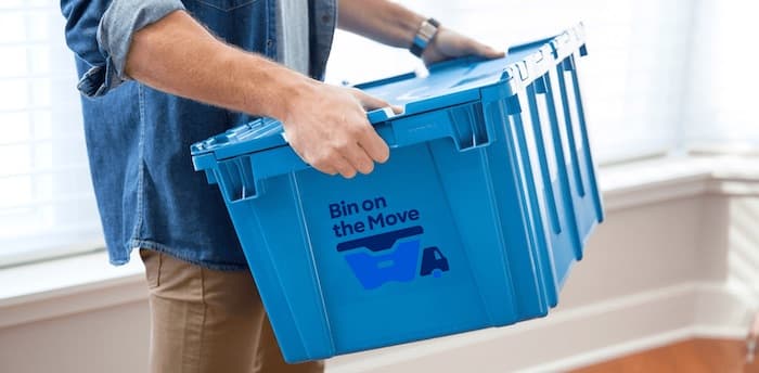 Person carrying Bin on the Move reusable moving bins on moving day